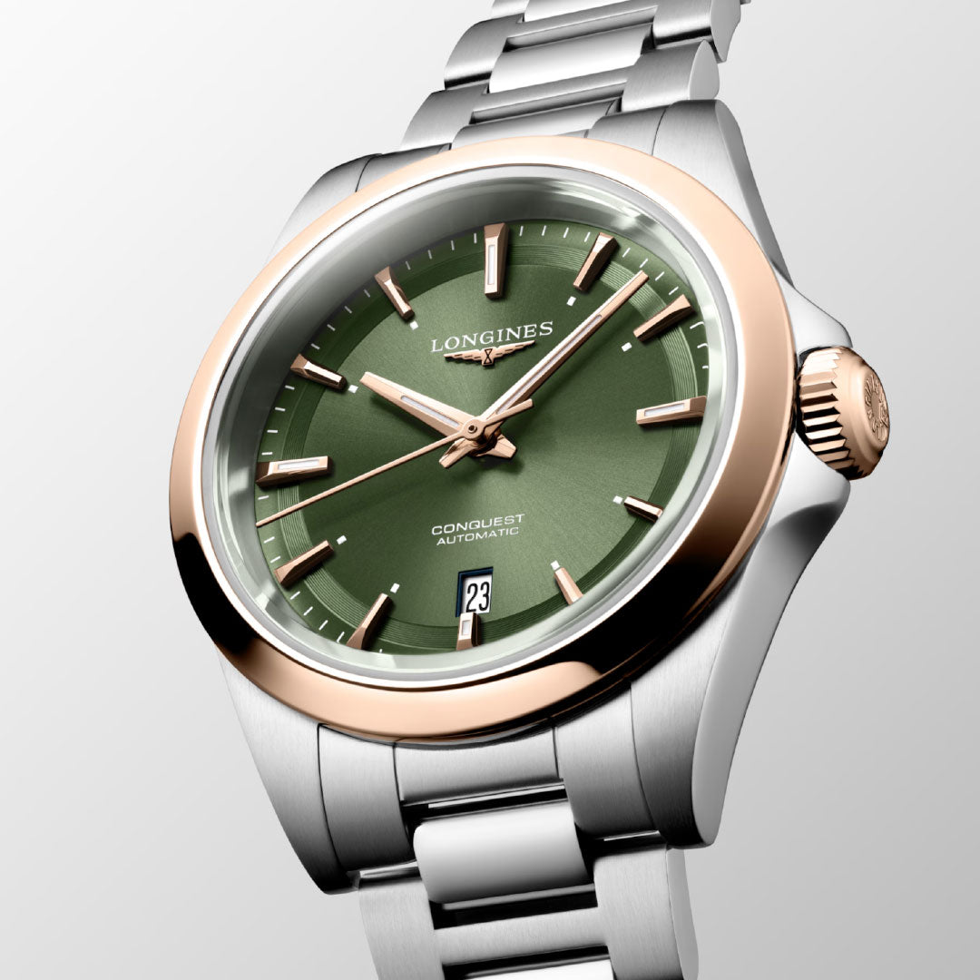 The Longines Conquest Automatic 30mm Watch features a green dial, rose gold bezel, silver stainless steel bracelet, and a date display at 6 o’clock—an elegant everyday timepiece from Longines.