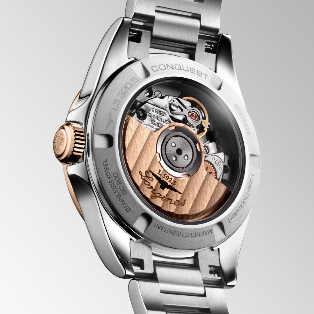 Close-up of the Longines Conquest Automatic 30mm Watch, highlighting its sporty elegance with visible gears, a rose gold rotor engraved “Longines,” and a stainless steel case and bracelet—a timeless everyday piece.