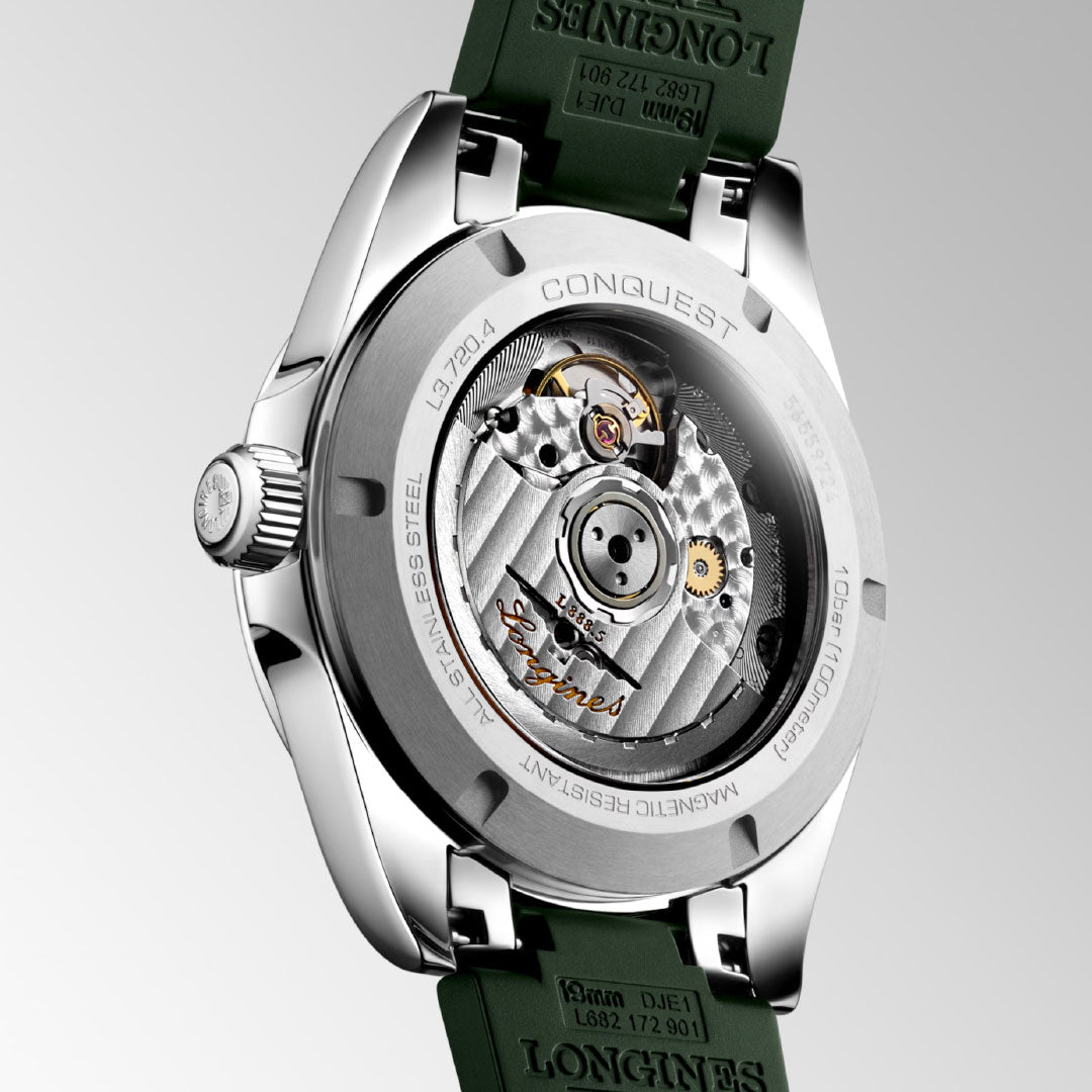 Close-up of the Longines Conquest Automatic 38mm Watch by Longines, highlighting its automatic movement visible through the transparent case back, green strap, and detailed engravings on the stainless steel case.
