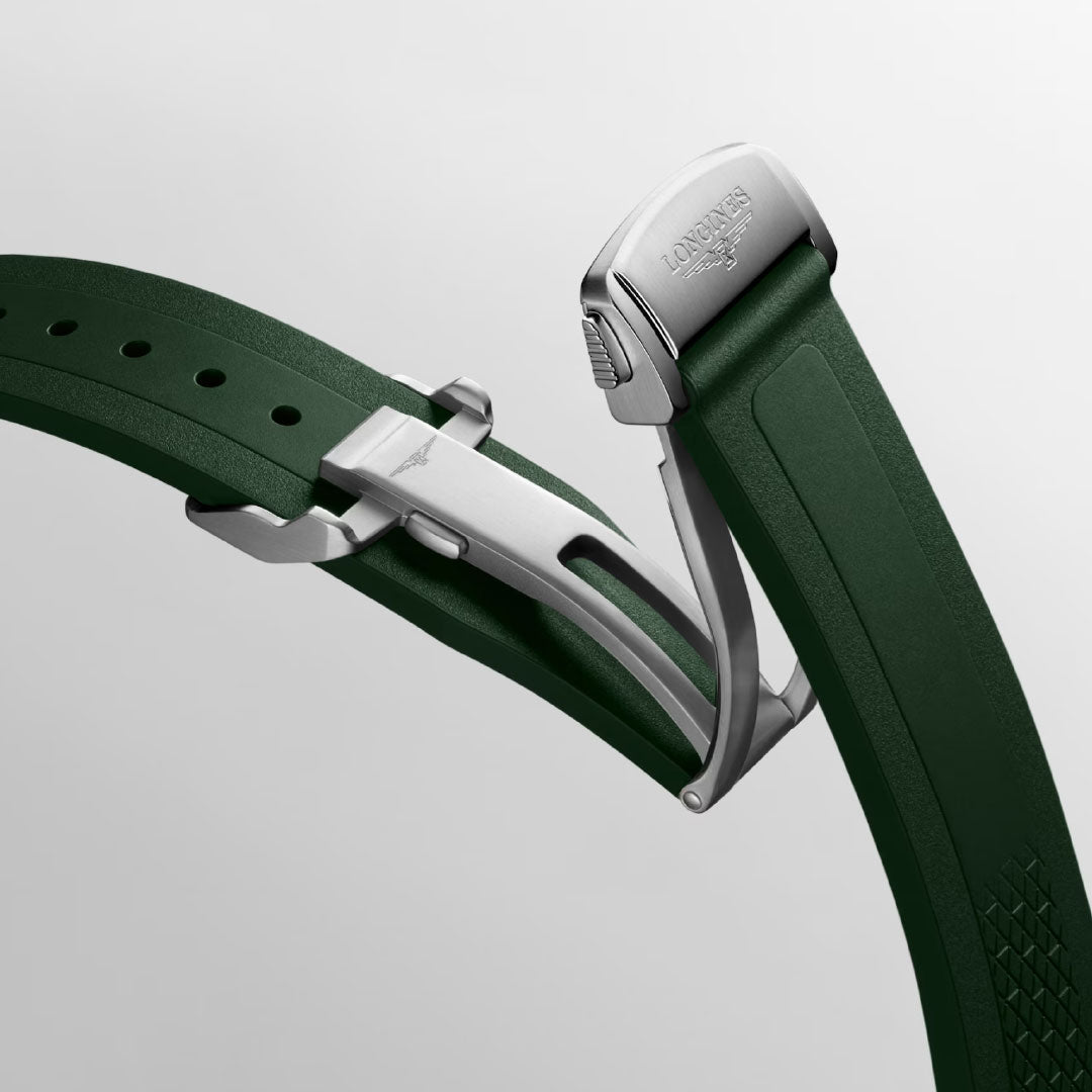 Close-up of a green rubber strap from the Longines Conquest Automatic 38mm Watch, featuring a silver folding clasp with an engraved Longines logo. The detailed mechanism is shown against a light gray background.