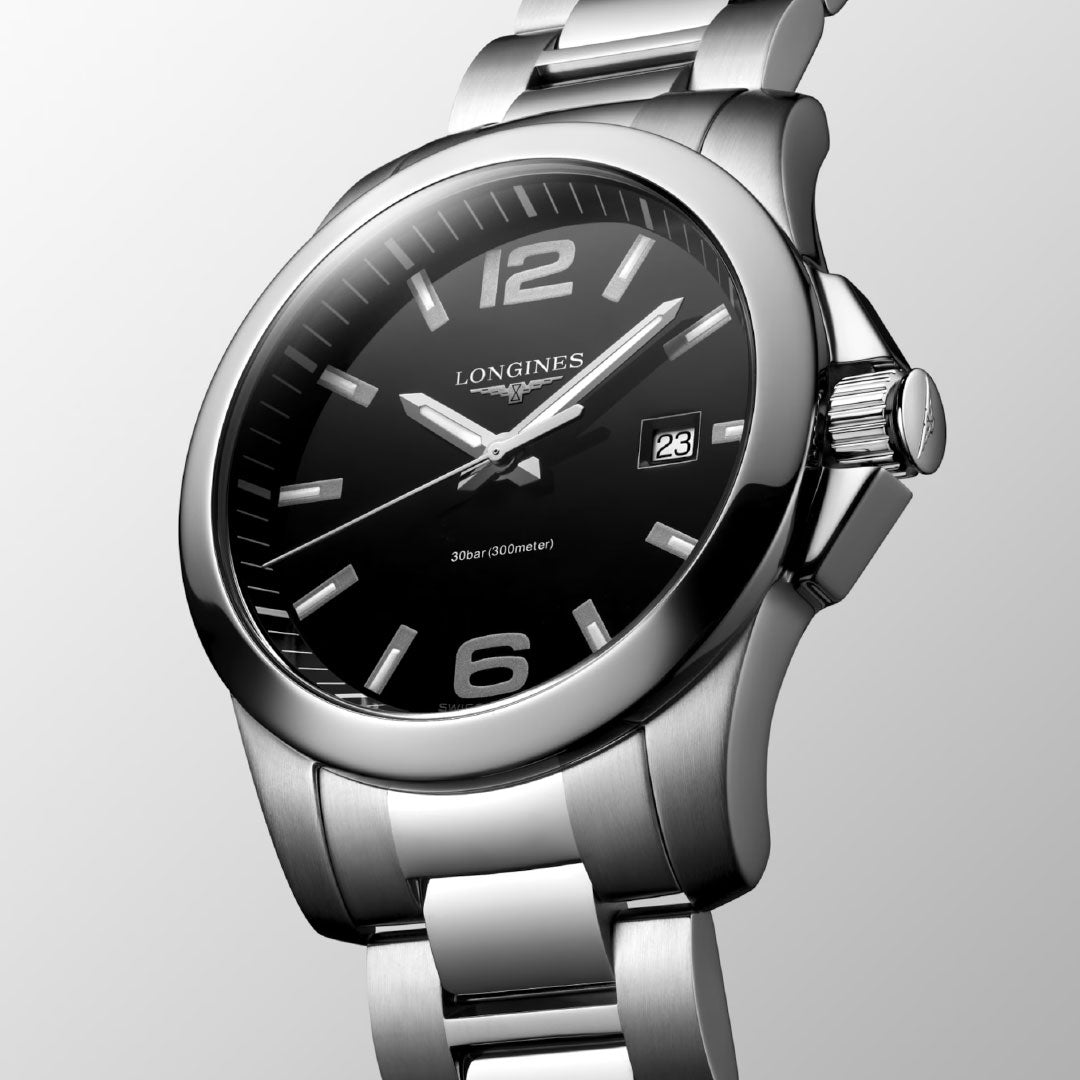 A close-up of the Longines Conquest Quartz 41mm Watch by Longines, showcasing its black dial, silver hour markers, date display at 3 o'clock, and stainless steel bracelet against a light gray background.