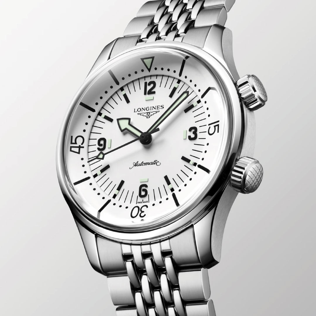 A close-up of the Longines Legend Diver Automatic 39mm Watch by Longines, featuring a stainless steel case, white dial with luminous hands and markers, internal rotating bezel, and metal bracelet against a light gray background.