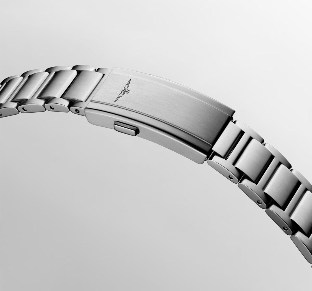 A close-up of the Longines Hydroconquest Automatic 39mm Watch’s stainless steel bracelet, with a brushed clasp and engraved logo, highlights its 300m water resistance against a light gray background.
