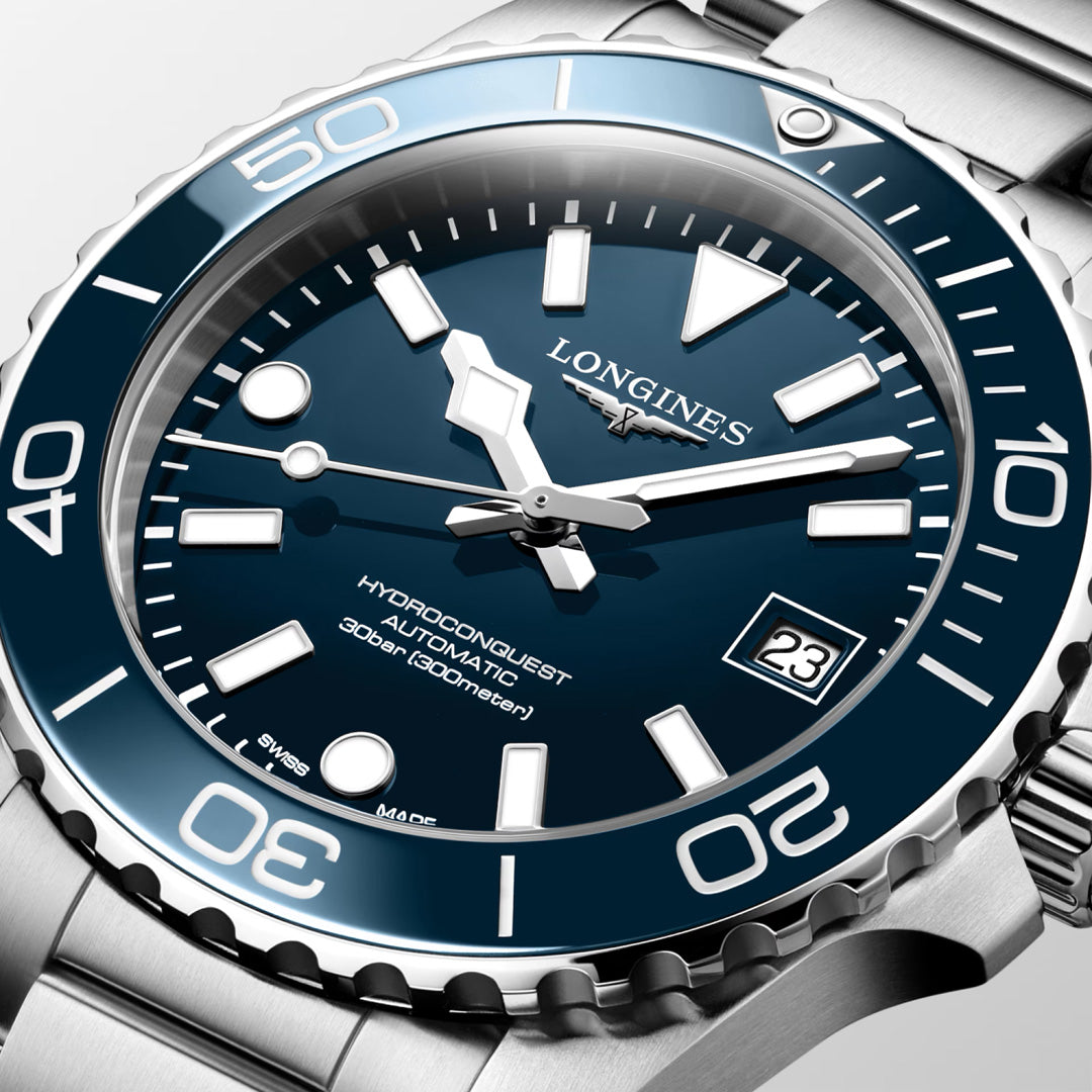 Close-up of the Longines Hydroconquest Automatic 39mm Watch with a stainless steel case, blue bezel, white hour markers, bold hands, automatic movement, date at 3 o’clock, and 300m water resistance.