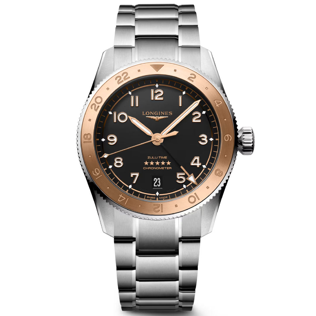 The Longines Spirit Zulu Time 1925 Automatic 39mm watch features a silver metal band, black dial, rose gold 24-hour bezel, gold numerals, a date window at 6 o’clock, five stars, and dual time zone functionality.