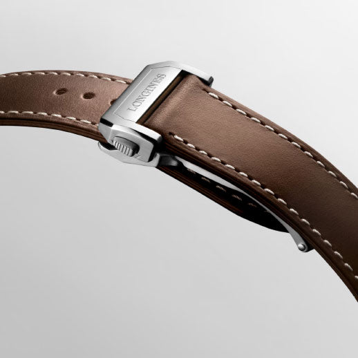 A close-up of a brown leather strap with white stitching and a silver "Longines" clasp highlights the refined Longines Spirit Pilot Automatic 39mm watch, set against a light grey background.