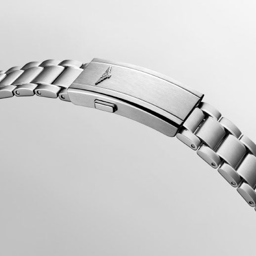 A close-up of the brushed silver metal clasp with engraved wing logo on the Longines Spirit Pilot Automatic 39mm watch, set against a plain light gray background.