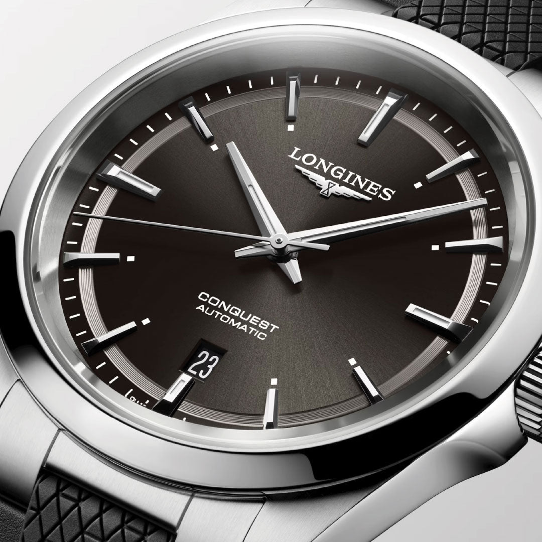 Close-up of the Longines Conquest Automatic 41mm Watch featuring a dark dial, silver indices, and a 6 o’clock date window. The stainless steel case and textured black strap from Longines make it an ideal everyday accessory.