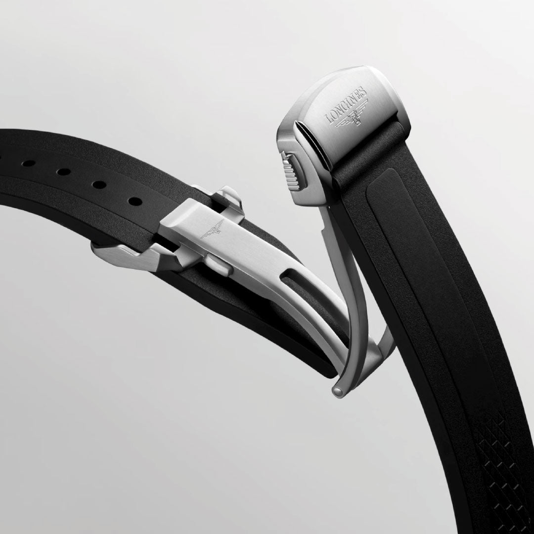 A close-up of the Longines Conquest Automatic 41mm Watch’s black rubber strap with a silver folding clasp engraved with the Longines logo, set against a light gray background.