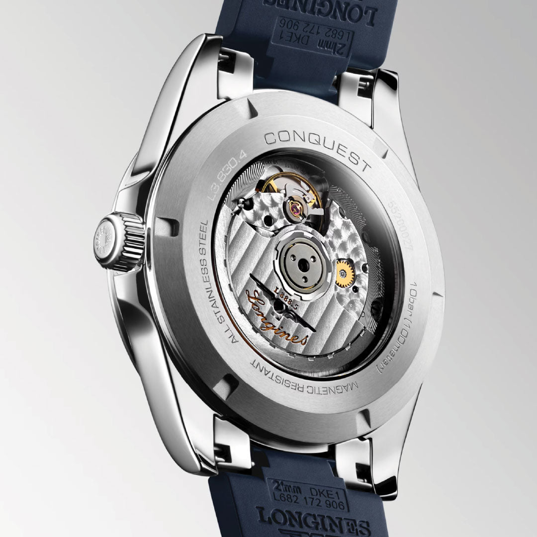 A close-up of the Longines Conquest Automatic 41mm Watch highlights its sporty elegance with a stainless steel case, transparent back displaying the movement, and a sophisticated blue strap—all crafted by Longines.