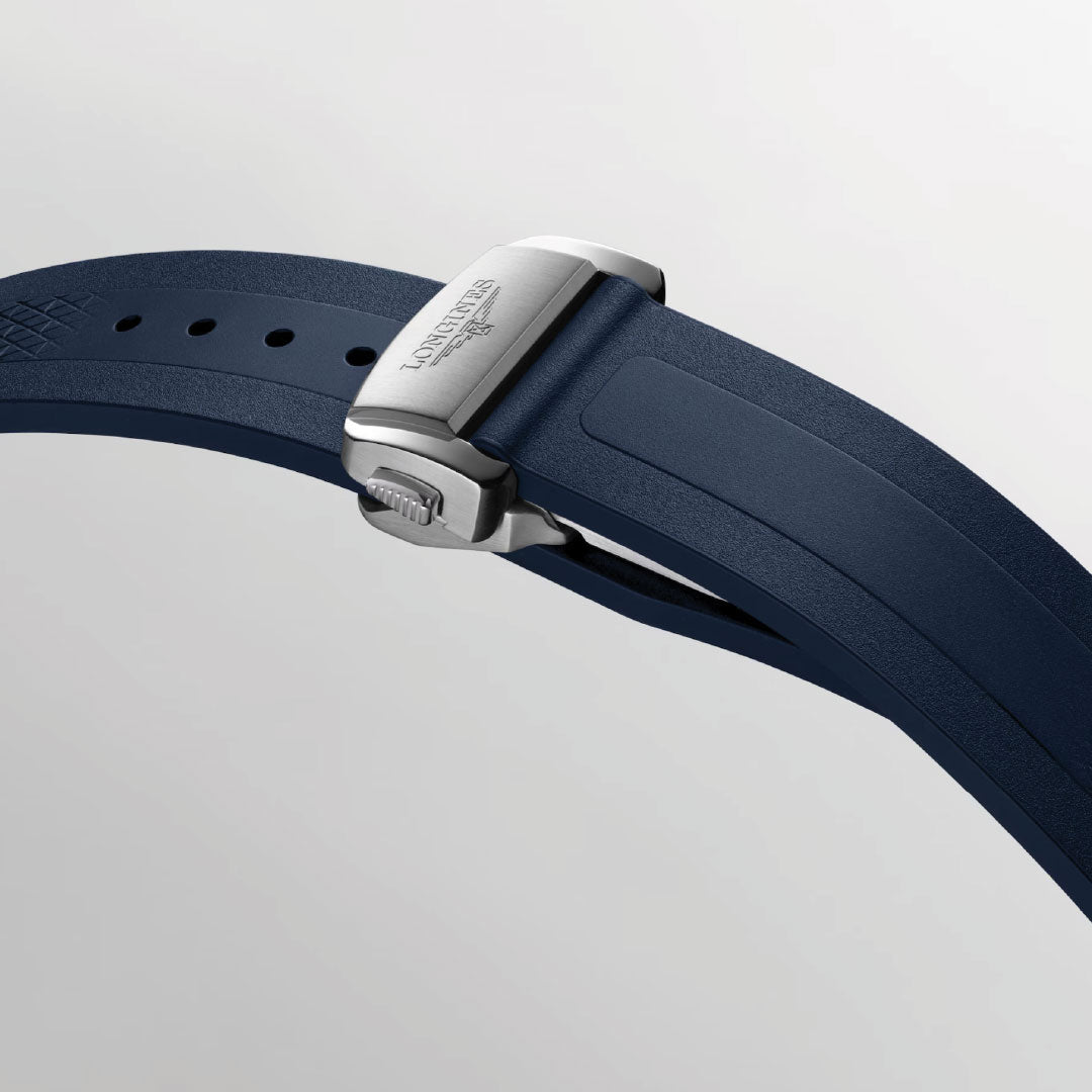 A close-up of a blue rubber strap with a silver clasp engraved "AQUANAUT" on light grey, echoing the sporty elegance and modern style of the Longines Conquest Automatic 41mm Watch by Longines.