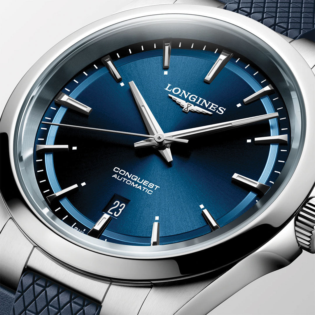 Close-up of the Longines Conquest Automatic 41mm Watch, highlighting its blue sunburst dial, silver markers, date at 6 o’clock, textured blue strap, and polished stainless steel case for a sporty yet elegant look.