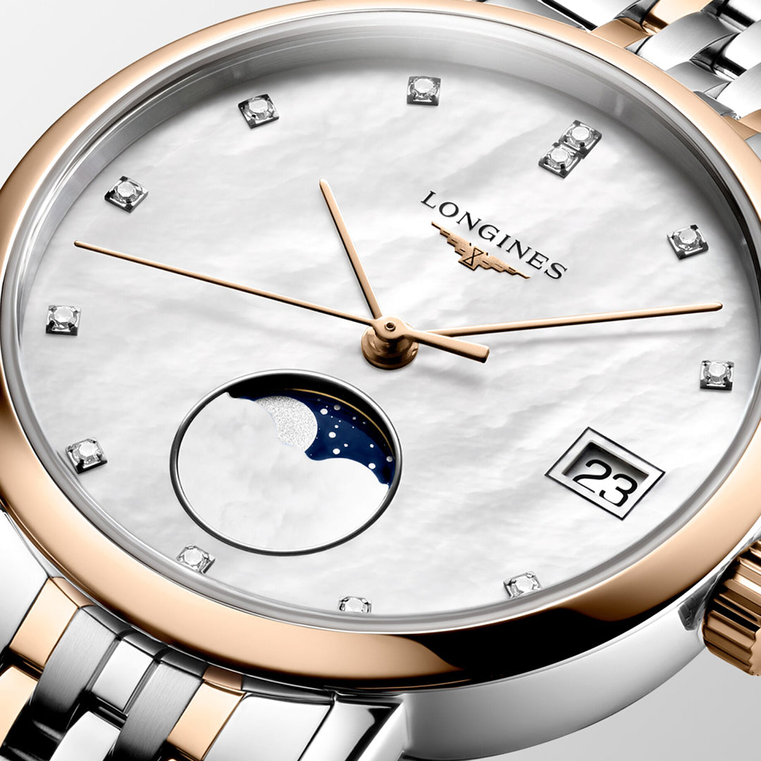 A detailed look at the Longines Elegant Collection Moonphase Quartz 37mm Watch reveals a white dial that exudes minimalist elegance, highlighted by gold hands, diamond hour markers, and a moon phase display. The Longines brand name embellishes the face, celebrating watchmaking tradition with its two-tone metal bracelet.