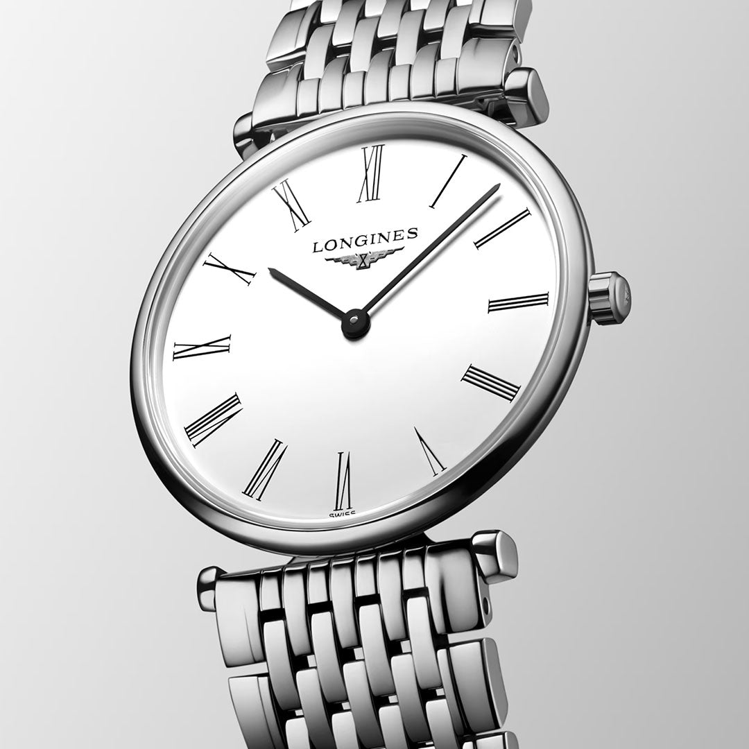 A detailed view of the Longines La Grande Classique Quartz 29mm Watch shows its silver metal link band, white oval face with black Roman numerals, and time at 10:10 against a light gray gradient, reflecting classic Longines elegance.