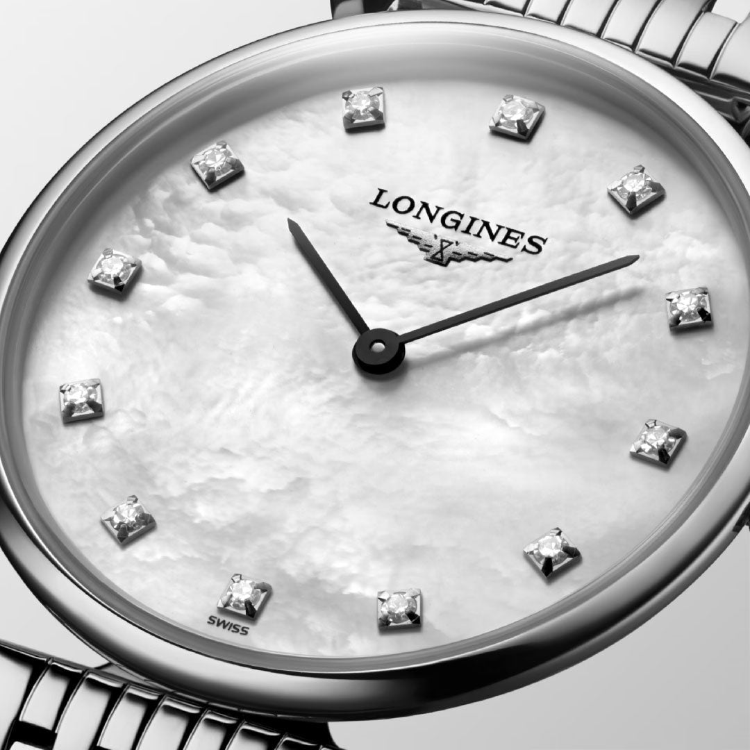 A close-up of the Longines La Grande Classique Quartz 29mm Watch, featuring a white mother-of-pearl dial with diamond markers, silver hands, and a classic stainless steel bracelet by Longines.
