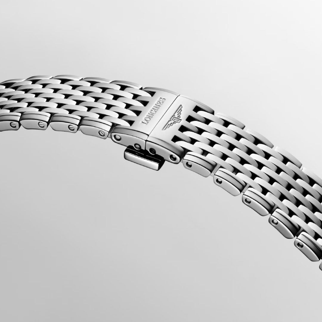 Close-up of the Longines La Grande Classique Quartz 29mm Watch’s silver bracelet, featuring a clasp engraved with the Longines logo and winged hourglass symbol, set against a light gray background—a refined detail of this elegant timepiece.