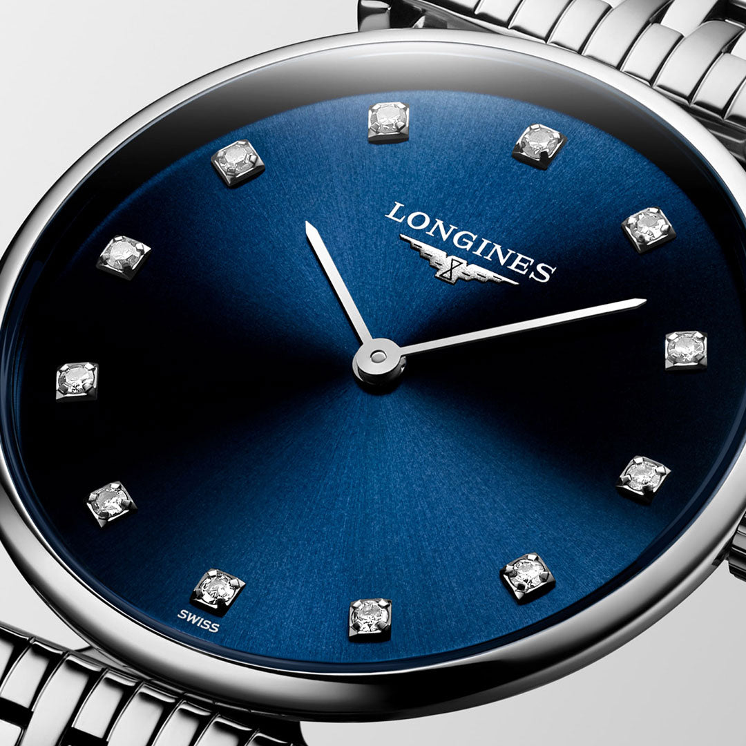 A close-up of the Longines La Grande Classique Quartz 29mm Watch features a blue sunburst dial with diamond hour markers, silver hands, and a sleek bracelet that showcases Longines' classic elegance.