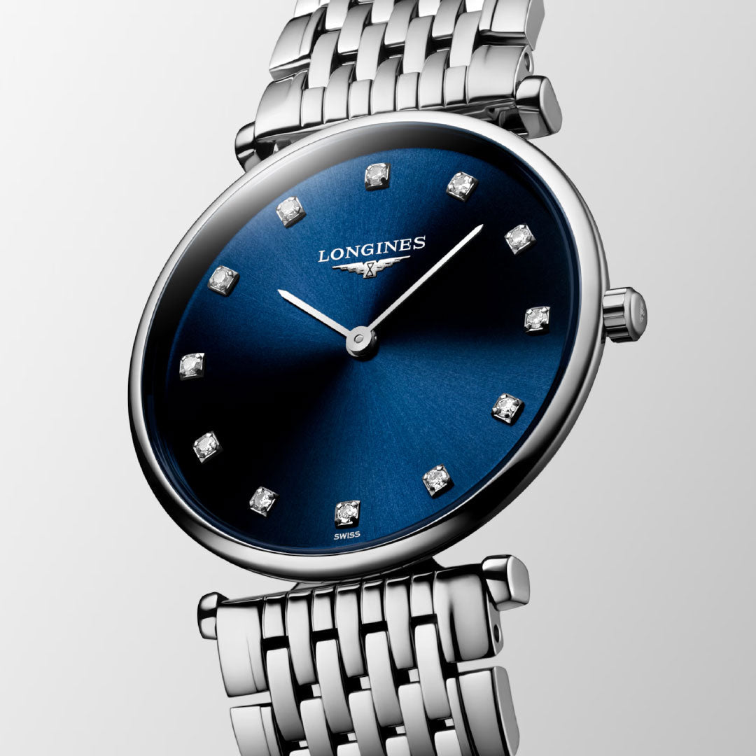 The Longines La Grande Classique Quartz 29mm Watch features a silver band, deep blue sunray-patterned dial with diamond hour markers and silver hands, blending timeless refinement with the luxury expected from Longines.