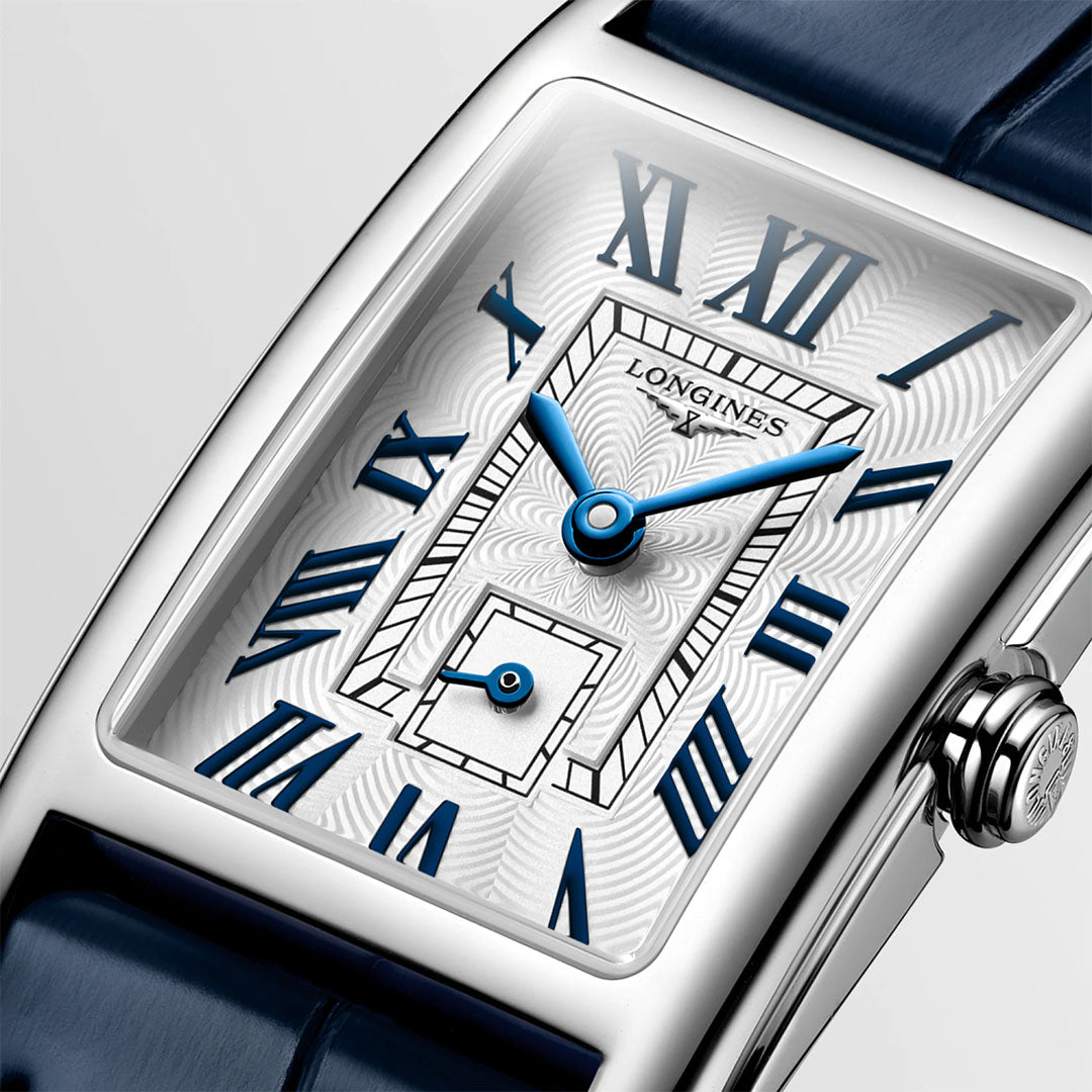 Showcasing the Longines Dolcevita Quartz 20.8 x 32mm Watch, this rectangular timepiece features a refined white patterned dial accented by striking blue Roman numerals and hands, a small seconds sub-dial, and a sophisticated dark blue leather strap—embodying Longines’ timeless elegance in luxury watchmaking.