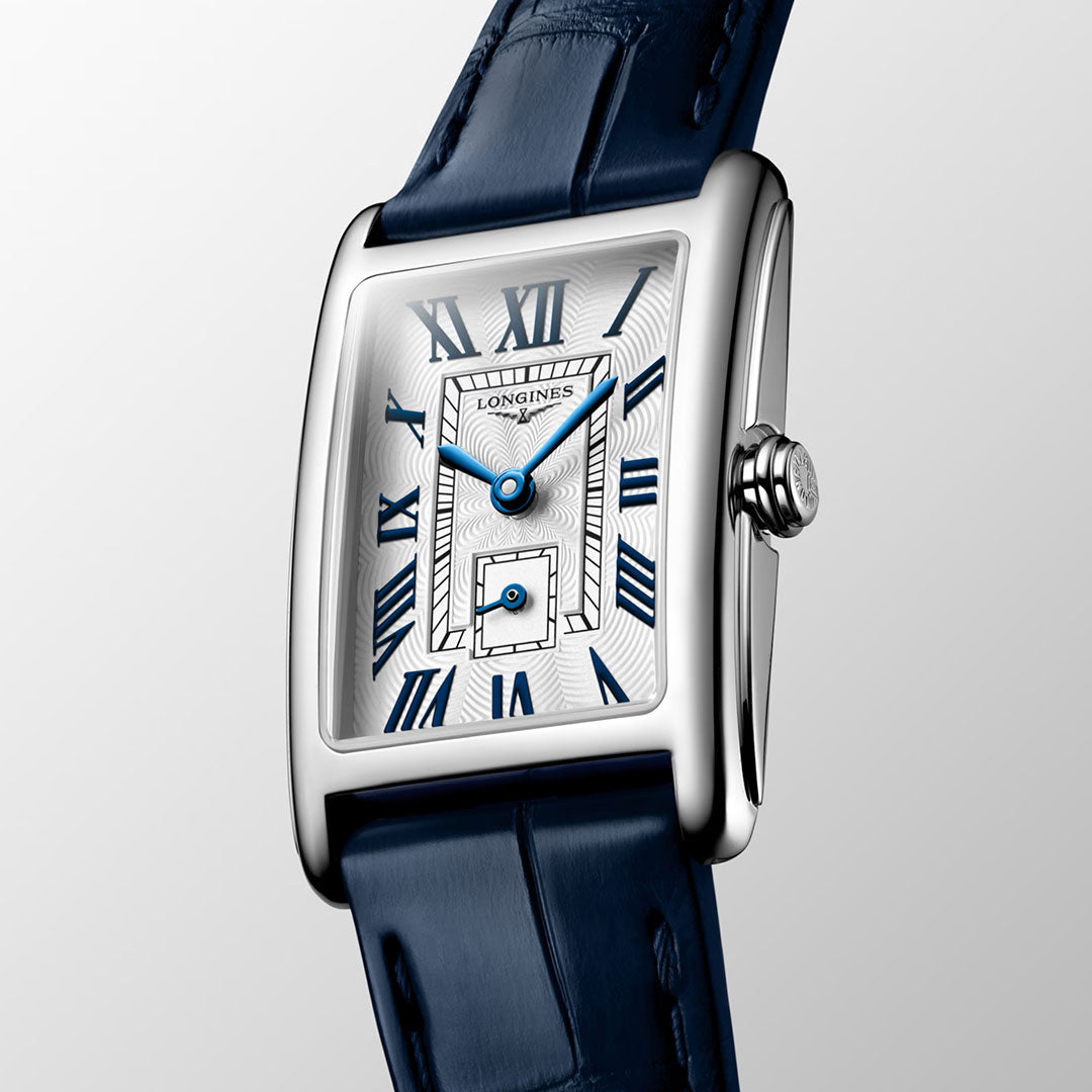 The Longines Dolcevita Quartz 20.8 x 32mm Watch by Longines features a rectangular silver case, a white dial with blue Roman numerals and blue hands, as well as a blue leather strap. The watch face includes a small seconds subdial and showcases the timeless elegance characteristic of the Longines DolceVita collection.