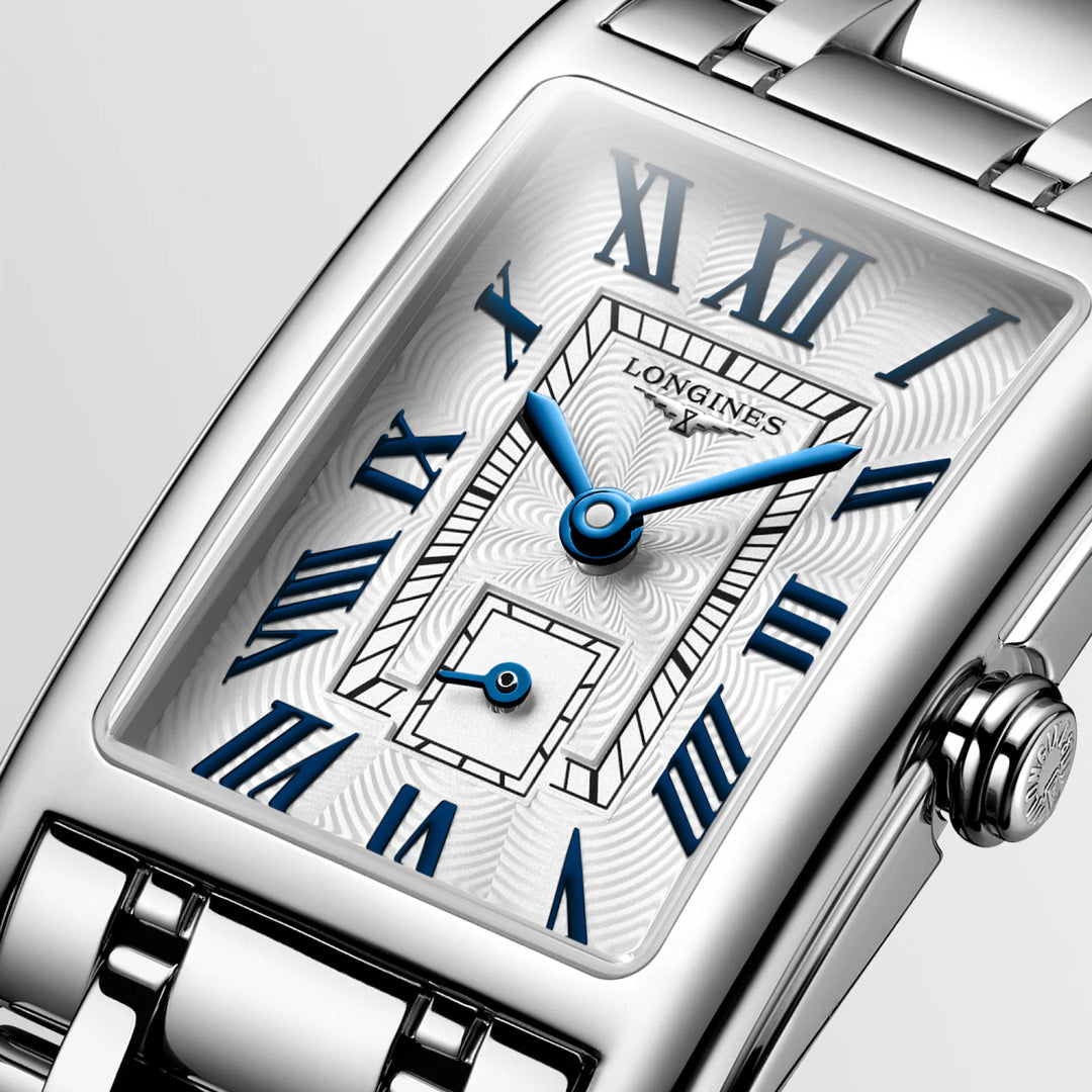 Close-up of a Longines Dolcevita Quartz 20.8 x 32mm Watch featuring a silver metal band, white textured dial, blue Roman numerals and hands, and a small seconds subdial—a showcase of Longines’ luxury and elegance.