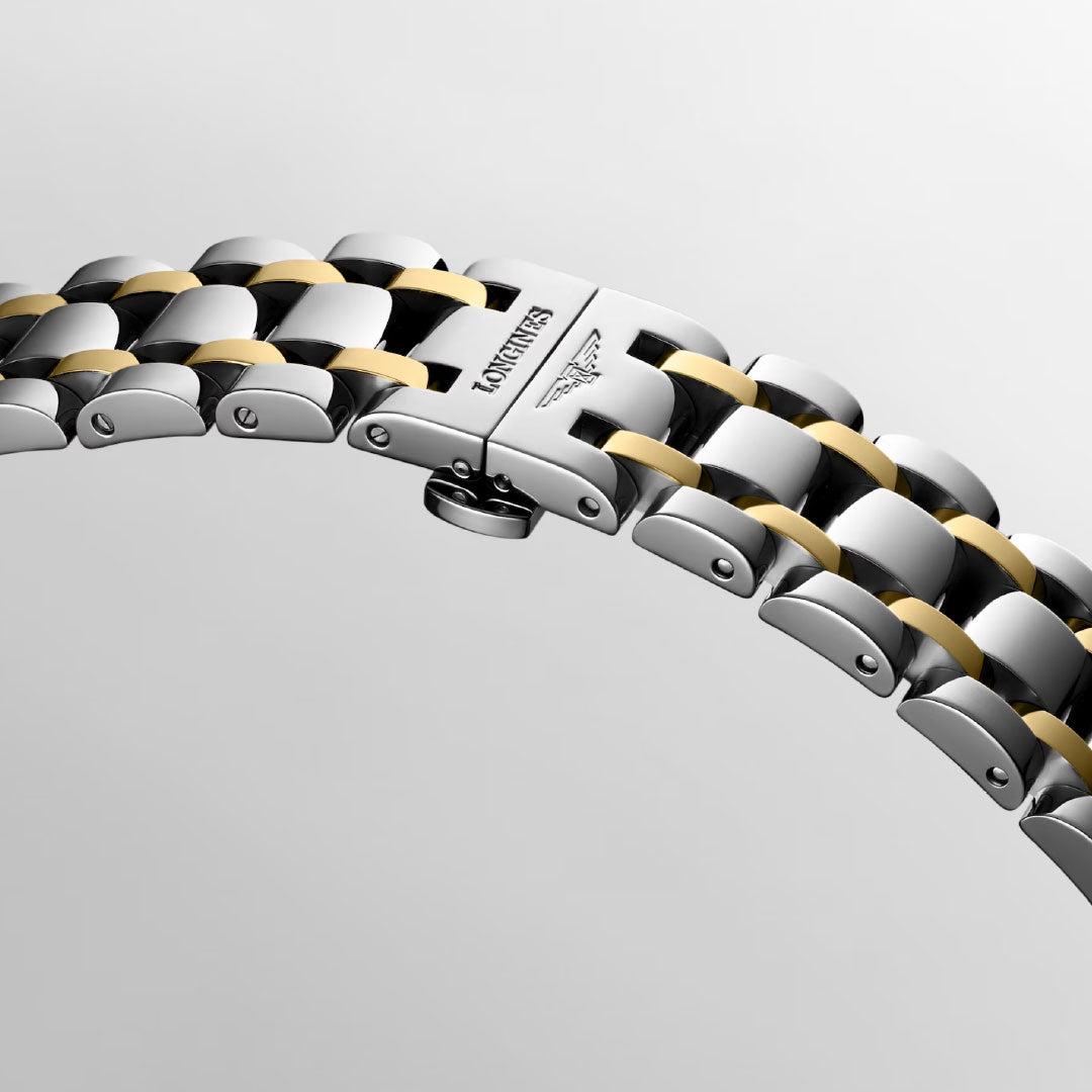 A close-up of a two-tone silver and gold bracelet with a clasp engraved with the Longines logo highlights the refined style of the Longines Dolcevita Quartz 20.8 x 32mm Watch against a light background.