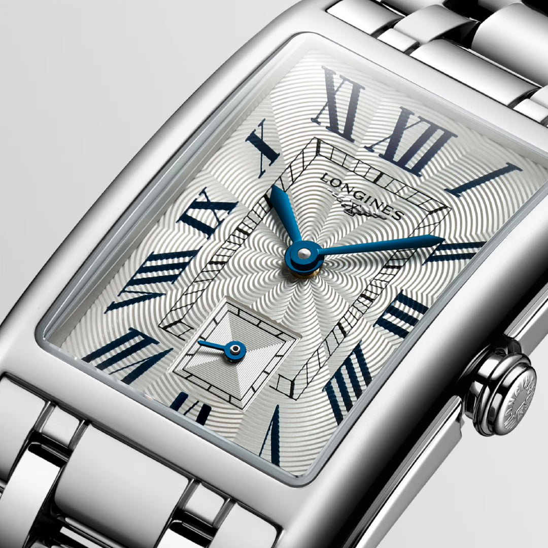 Close-up of the Longines Dolcevita Quartz 23.30 x 37mm watch with a rectangular case and textured dial, featuring blue hands, Roman numerals, and a small subdial. The metallic bracelet completes its timeless elegance.