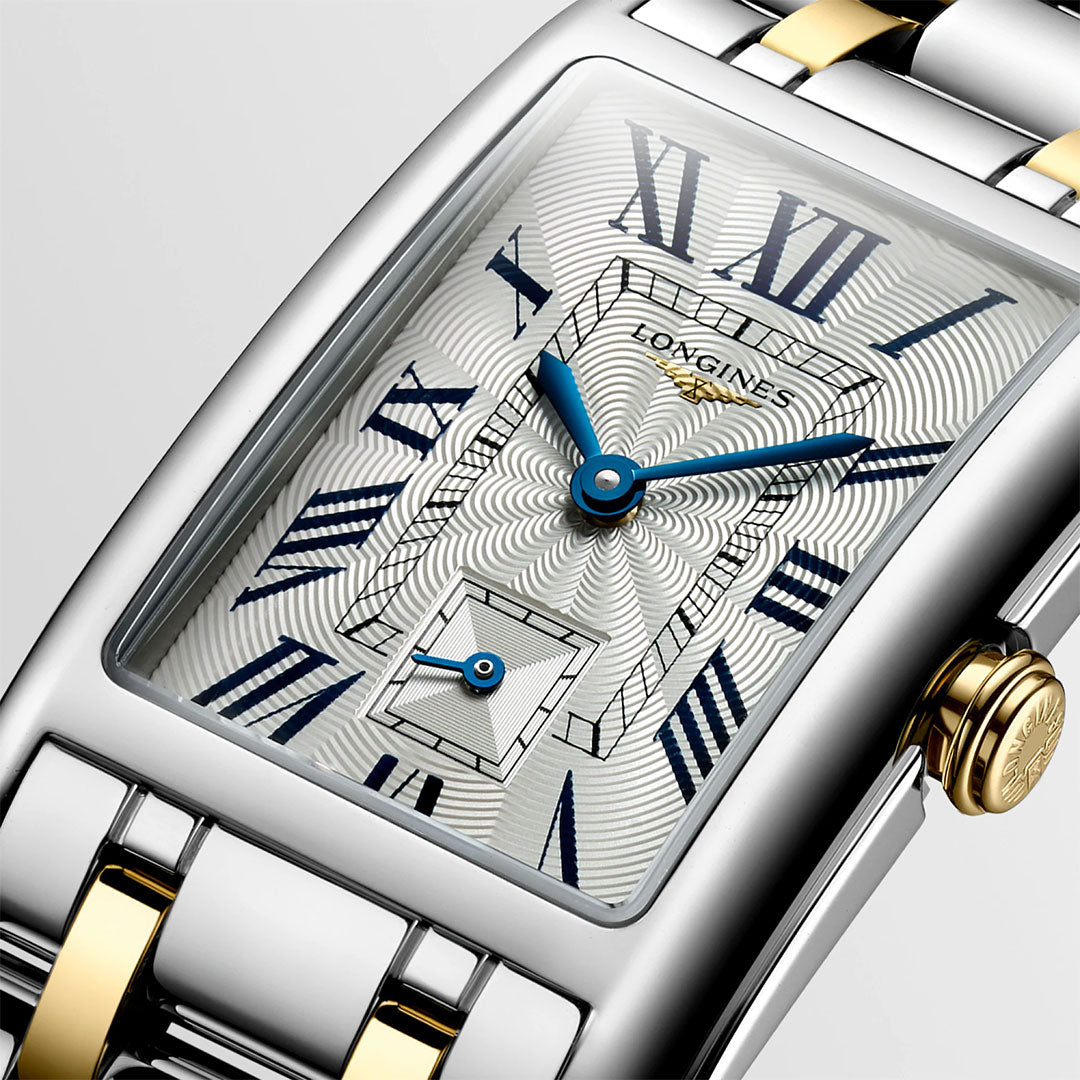 Close-up of the Longines DolceVita Quartz 23.3 x 37mm Watch, featuring a rectangular silver and gold case, blue Roman numerals and hands, textured silver dial, and two-tone bracelet—timelessly elegant from Longines.