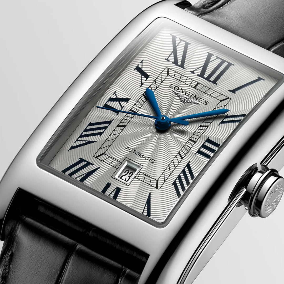 Close-up of the Longines Dolcevita Automatic 27.7 x 43.8mm Watch, featuring a rectangular silver case, textured white dial with blue hands and Roman numerals, date at 6 o’clock, and a black leather strap—timeless Longines elegance.