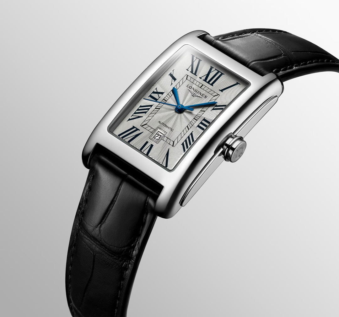 The Longines Dolcevita Automatic 27.7 x 43.8mm Watch features a silver rectangular case, black leather strap, white dial with Roman numerals and blue hands, plus a date window at 6 o’clock—a showcase of timeless elegance from Longines.
