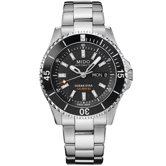 The MIDO Ocean Star GMT Automatic 44mm Watch features a stainless steel case, black dial, silver markers, day-date display, orange accents, and a metal link bracelet.