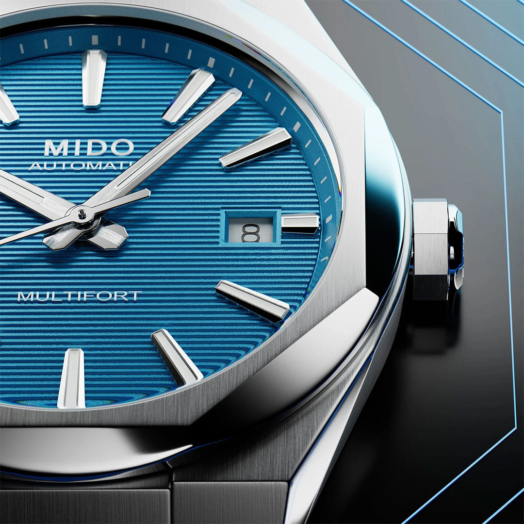 Close-up of the MIDO Multifort 8 One Crown Automatic 40mm Watch, featuring a blue textured dial, silver markers and hands, date at 3 o’clock, octagonal bezel, and brushed stainless steel case.
