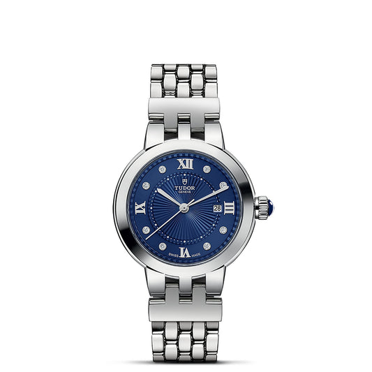 A chic TUDOR Clair de Rose wristwatch in silver, featuring a blue sunray-patterned dial with Roman numeral and diamond hour markers. It includes a date window at the 3 o'clock position and comes with a metal link bracelet. The steel case adds to its classic elegance fused with modern design.