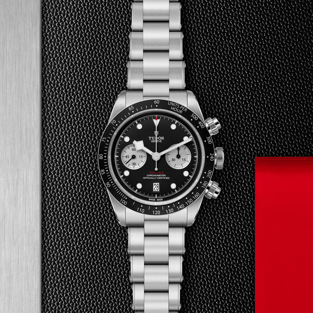 Experience luxury with the TUDOR Black Bay Chrono. Crafted in stainless steel, it features a black sports chronograph dial with silver hour markers, three sub-dials, and a striking red accent. Its T-Fit clasp ensures both style and functionality.