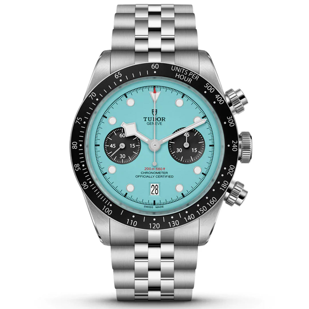 The TUDOR Black Bay Chrono features a turquoise stainless steel face, three black subdials, silver hour markers, a black tachymeter bezel, and a date window at 6 o'clock. It includes a metal link bracelet.