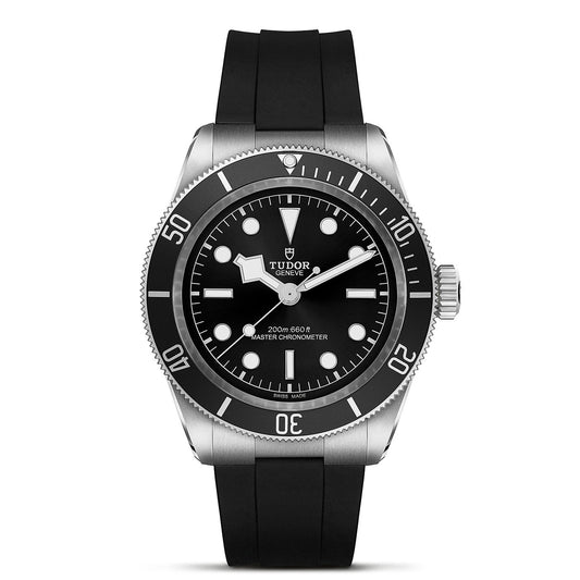 The TUDOR Black Bay wristwatch boasts a neo-vintage design with a black dial featuring luminous markers, a rotating bezel, and a sleek black rubber strap. Its watch face showcases three hands along with the TUDOR logo positioned below the 12 o'clock spot, embodying its signature design hallmark in divers' watches.