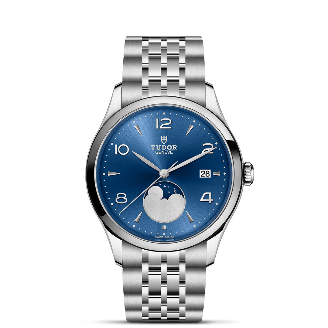 The TUDOR 1926 Luna is a stainless steel wristwatch with a blue dial, silver hour markers, date display, and moonphase at 6 o’clock on a silver link bracelet—a timeless classic from TUDOR.