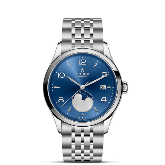 The TUDOR 1926 Luna is a stainless steel wristwatch with a blue dial, silver hour markers, date display, and moonphase at 6 o’clock on a silver link bracelet—a timeless classic from TUDOR.