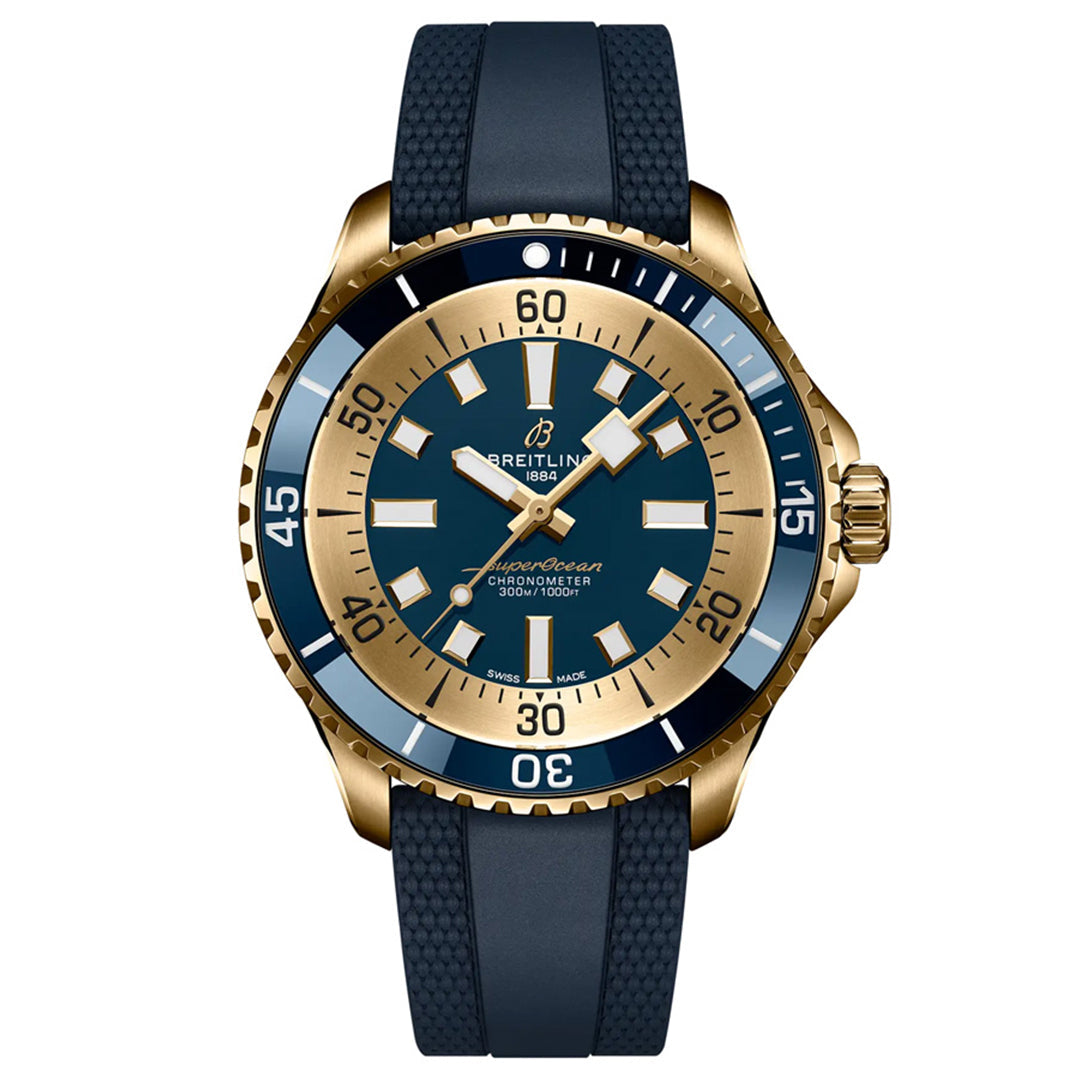 The BREITLING Superocean Automatic 44 boasts a gold and blue bezel, luminescent indexes on a dark blue face, matching strap, white and gold hour markers and hands, Breitling branding, and a date window, making it an exquisite dive watch.