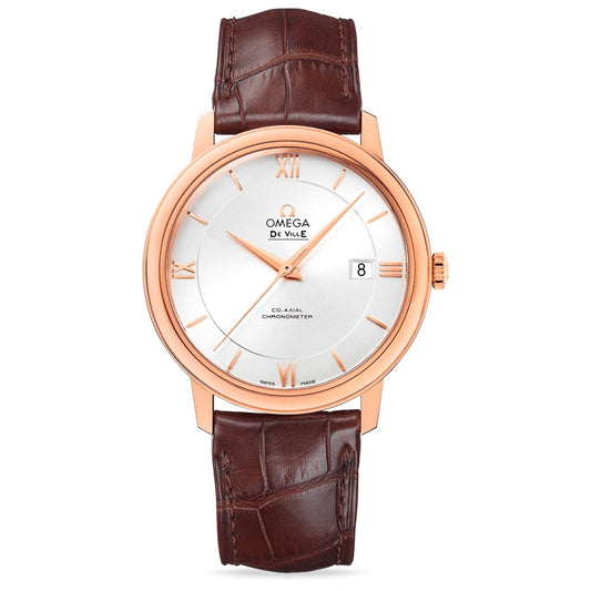 The OMEGA De Ville Prestige Co-Axial Chronometer 39.5mm Watch features a timelessly elegant design with a round silver dial, a rose gold bezel and case, Roman numeral markers, and a brown leather strap. "OMEGA" is displayed on the dial along with "Co-Axial Chronometer," accompanied by a date window positioned at 3 o'clock.