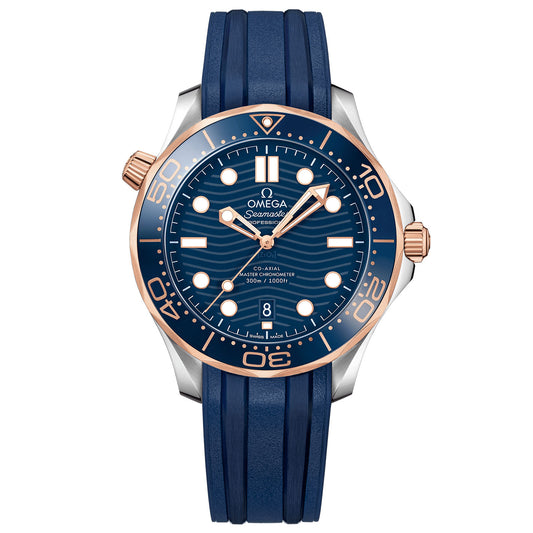 The OMEGA Seamaster Diver 300M Co-Axial Master Chronometer 42mm Watch features a luxurious blue dial and bezel adorned with rose gold accents crafted from 18K Sedna™ gold. It is paired with a blue rubber strap highlighting the Omega Seamaster Professional Diver 300M logo. The watch elegantly displays the time with bold white markers and hands, exemplifying the precision synonymous with OMEGA Master Chronometers.