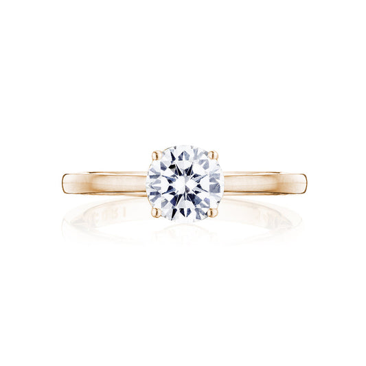 The Tacori Coastal Crescent 14K Rose Gold Round Brilliant Solitaire Semi Mount with a diamond-accented band is elegantly displayed against a white background. Skillfully crafted by TACORI gemologists, this engagement ring epitomizes elegance and sophistication, making it the ideal choice for those in search of timeless beauty.