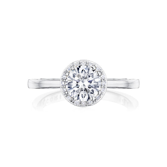 The Tacori Coastal Crescent 14K White Gold Round Brilliant Semi Mount Engagement Ring features a central round-brilliant diamond surrounded by a halo of smaller diamonds. Its slender, smooth band complements the design's elegance, reflecting the craftsmanship of TACORI gemologists.