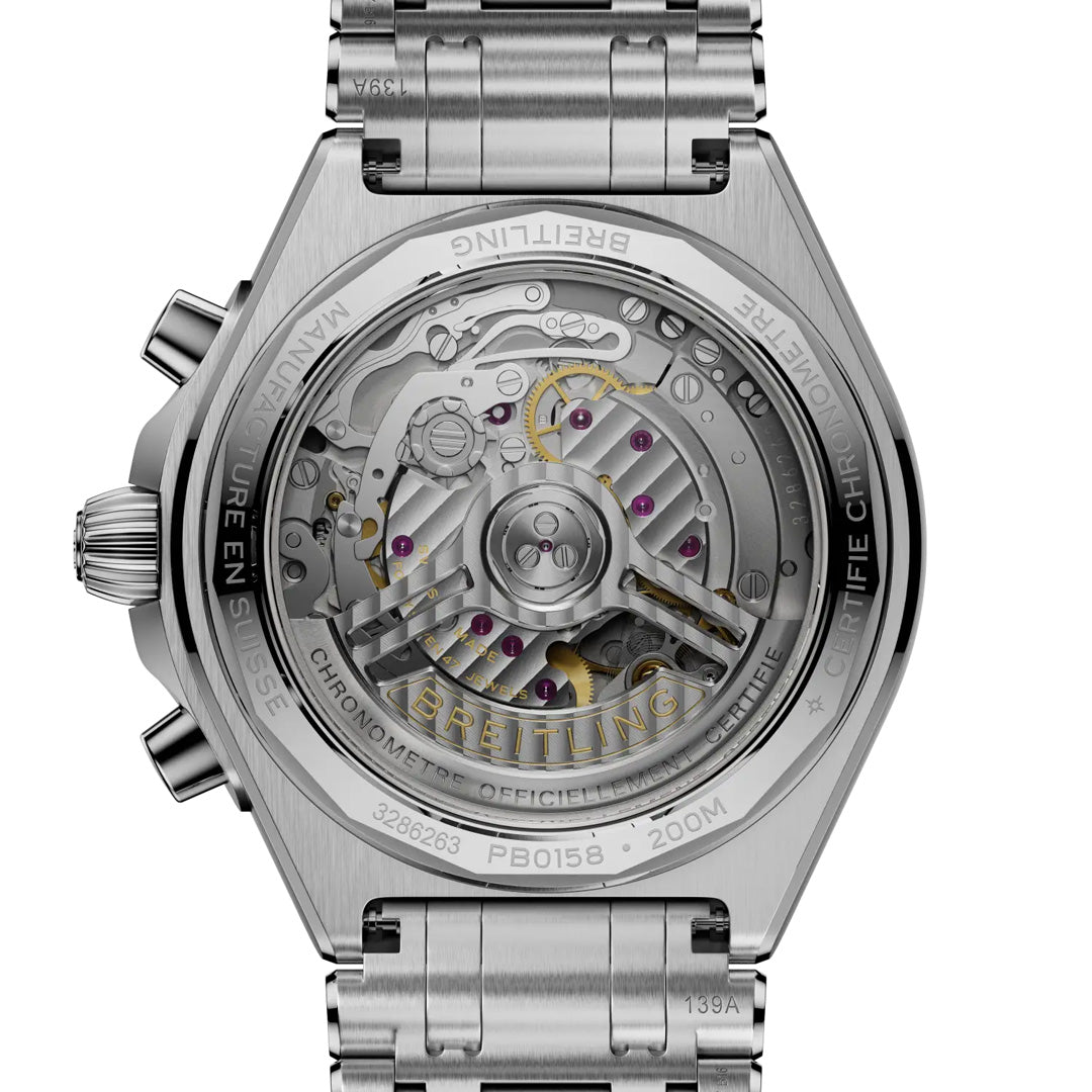 Close-up of the back of the BREITLING Chronomat B01 Chronograph 42, showing intricate inner mechanics and gears through its transparent case back, surrounded by Breitling’s engraved text on the metal edge.