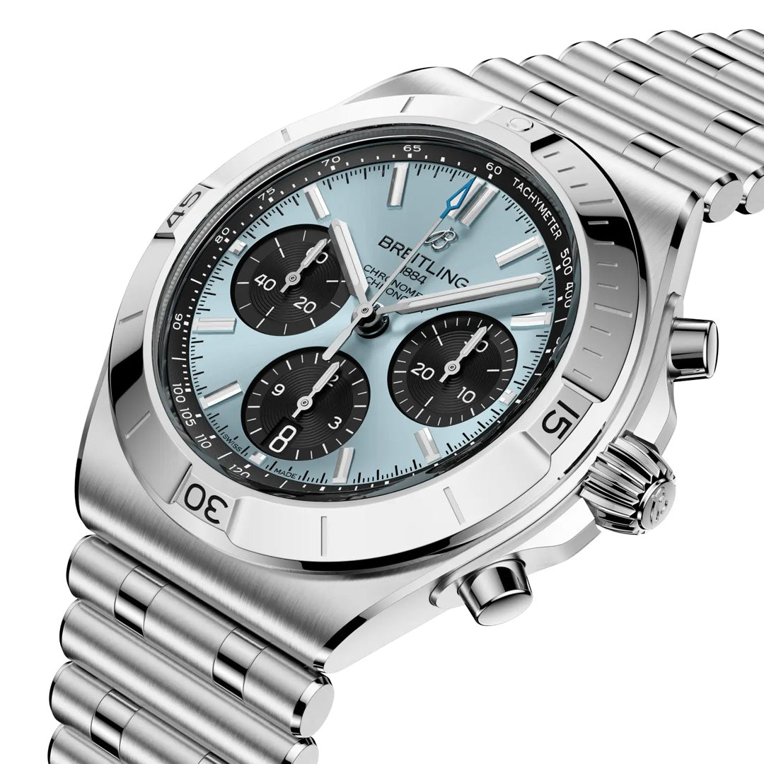 The Breitling Chronomat B01 Chronograph 42 is a luxury sports watch with a silver metal bracelet, light blue dial, three black subdials, tachymeter bezel, and chronograph pushers on the right.