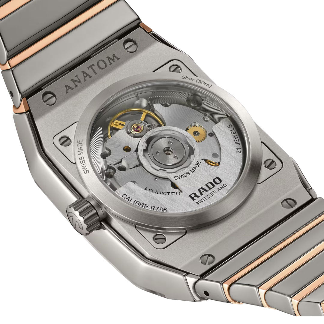 Close-up of the RADO Anatom Automatic 32.5mm Watch, showing its transparent sapphire case back that displays the mechanical movement and a metal bracelet with silver and rose gold accents.