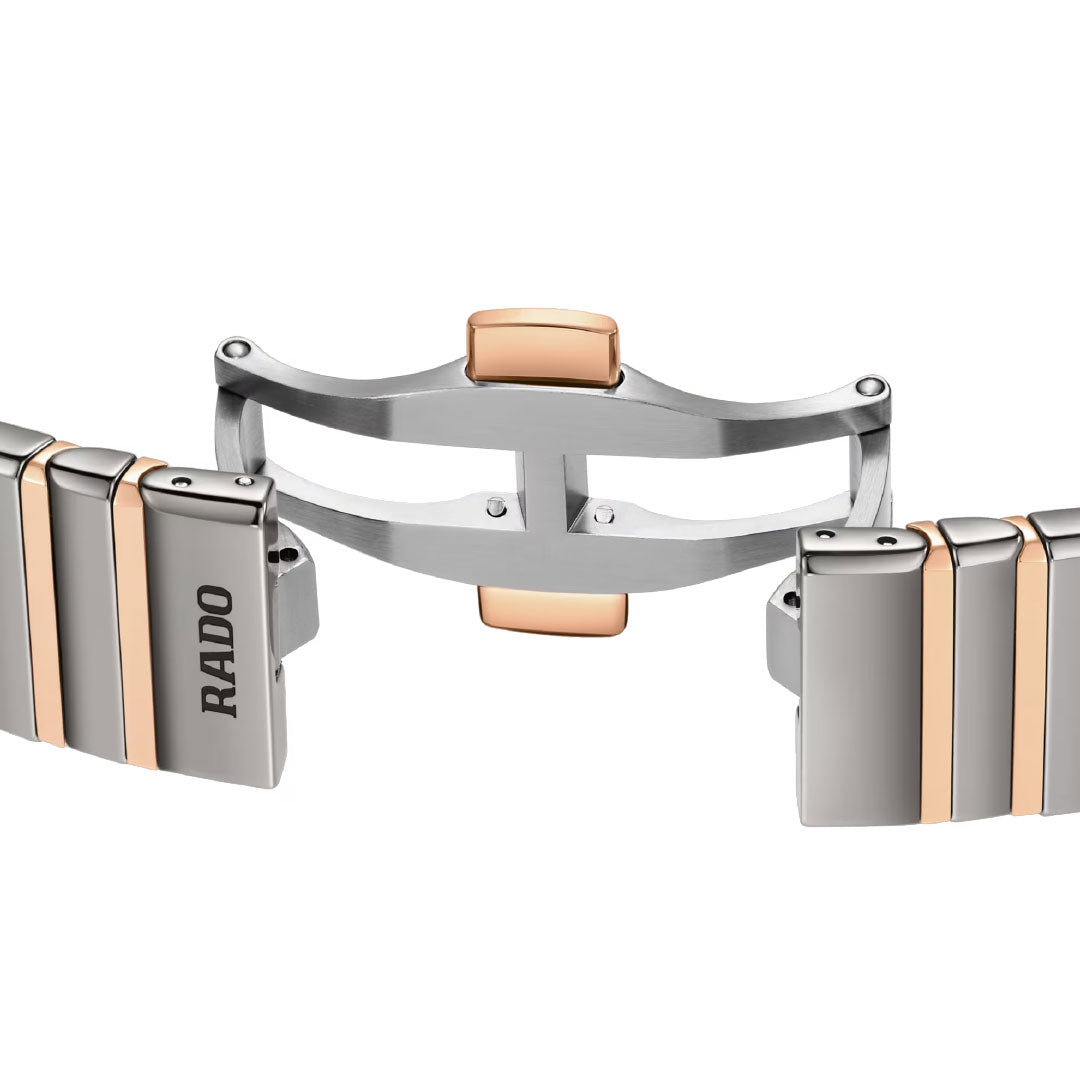 A close-up of the RADO Anatom Automatic 32.5mm Watch bracelet showcases alternating silver and rose gold links, a secure folding clasp, and the brand's signature sapphire crystal durability.