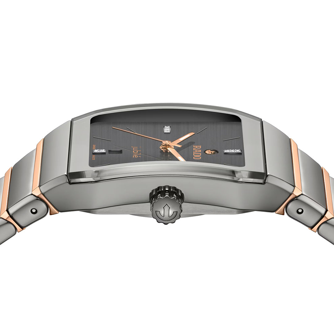 Close-up of the RADO Anatom Automatic 27.5mm Watch, a contemporary timepiece featuring a rectangular black face with rose gold hands and hour markers, silver detailing, and a sleek metallic band. Inspired by the iconic Rado Anatom design, this high-tech ceramic watch displays a distinctive emblem on the crown. Sophisticated in style and powered by an automatic movement, it beautifully highlights RADO’s signature blend of innovation and elegance.