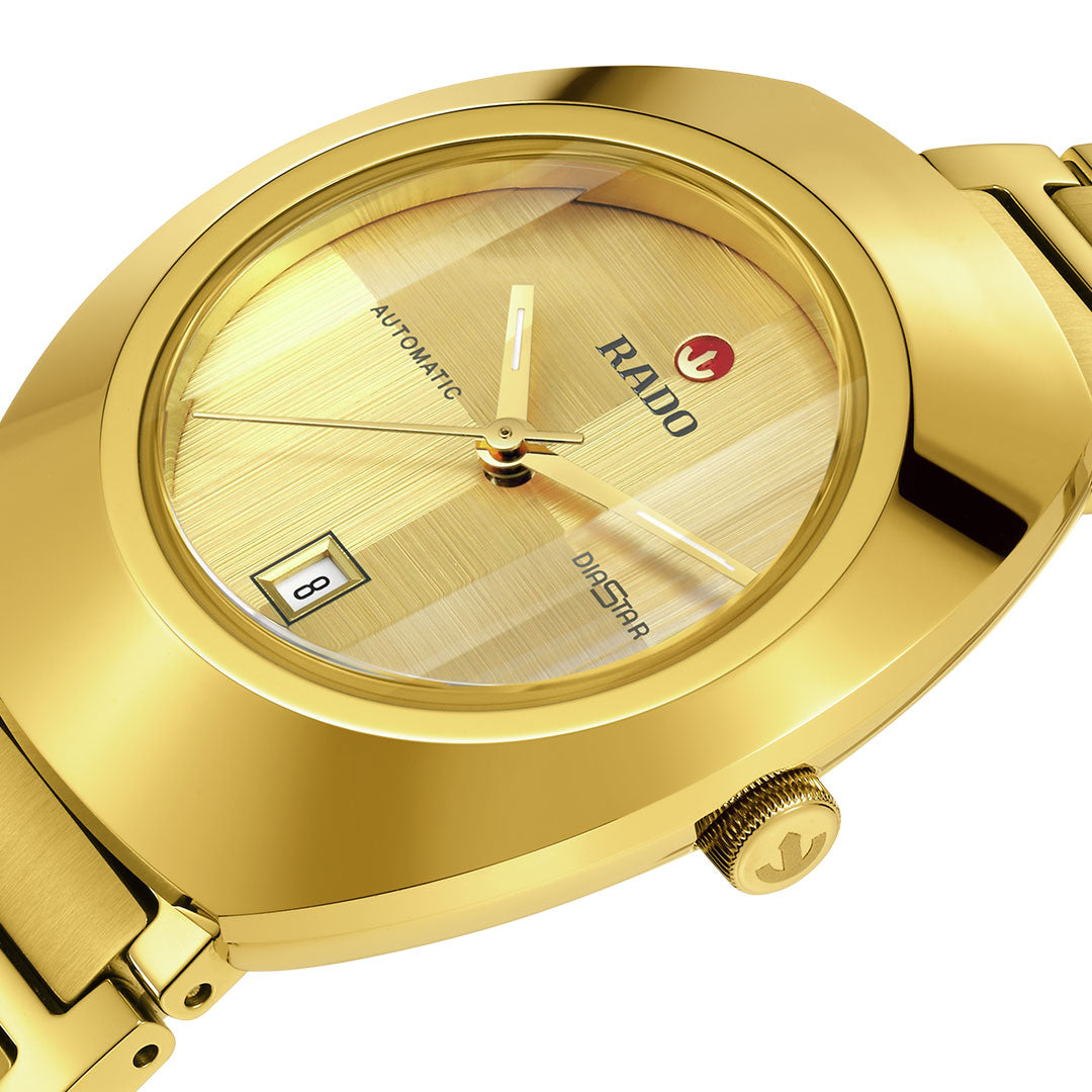 Close-up of a RADO Diastar Original Automatic 30mm watch featuring a gold face, automatic movement, date window set to the 8th, and gold metal strap. The RADO logo appears on both the crown and watch face.
