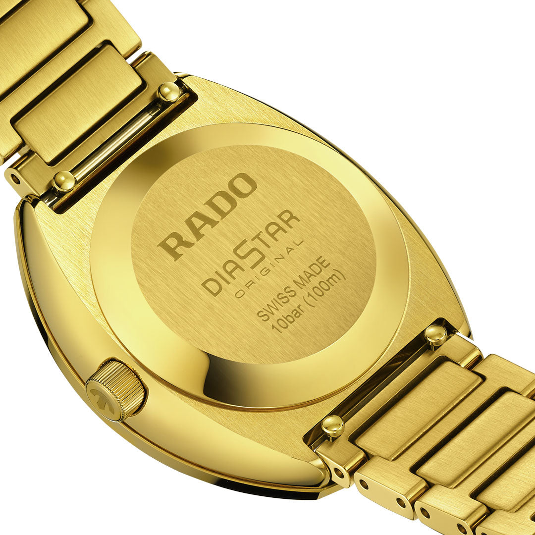 Close-up of the back of a gold RADO Diastar Original Automatic 30mm watch, showcasing Swiss craftsmanship and engraved details like "RADO," "Diastar Original," "Swiss Made," and "100bar (100m)" on the metallic case and bracelet.